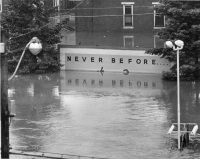 A half-submerged billboard on South Cameron Street proclaims the message Never Before...